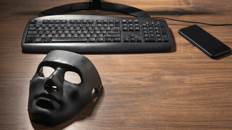 Black mask and computer on the table.
